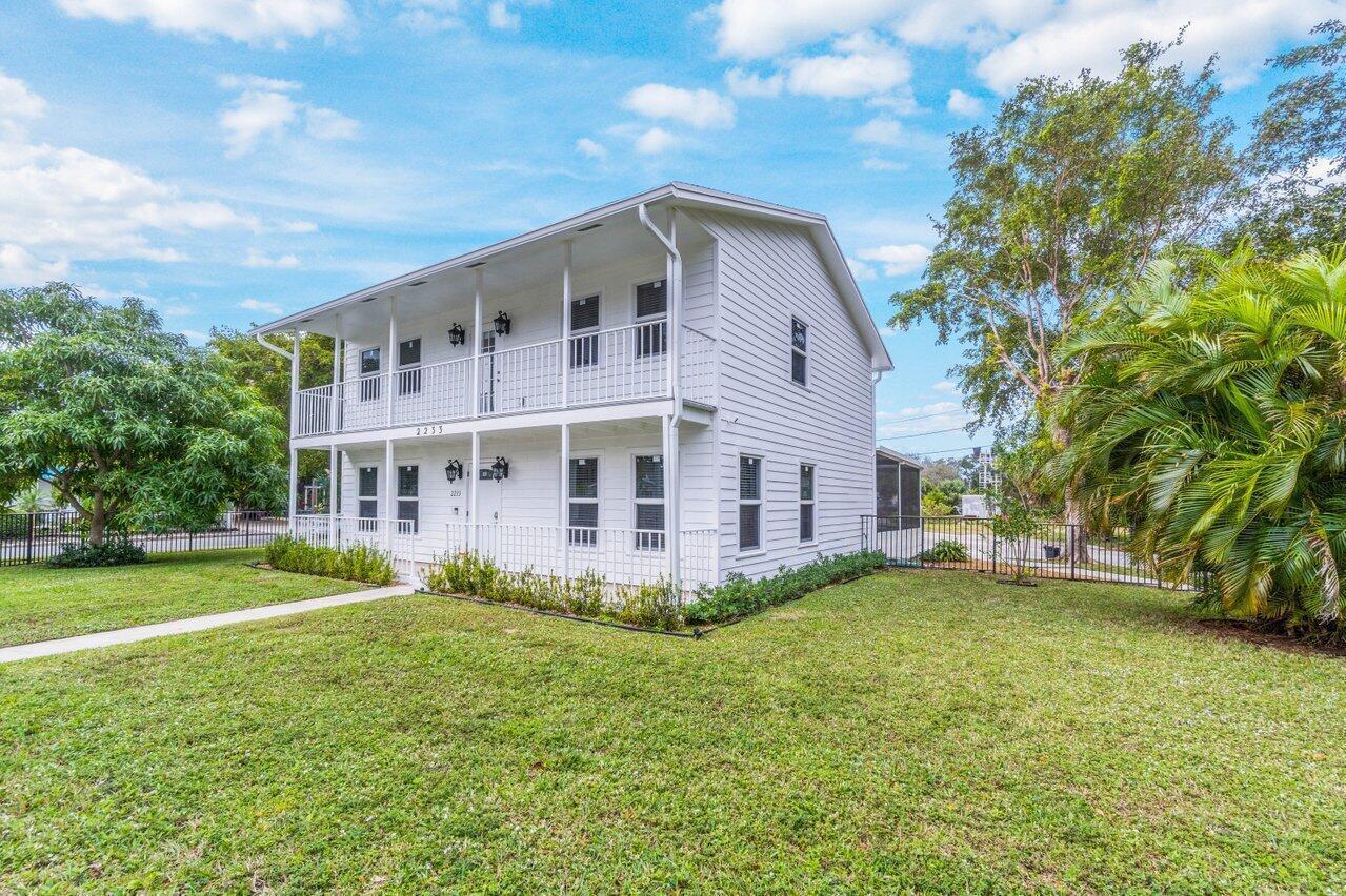 A two-story white house with a wrap-around balcony and a grassy front yard — 2233 Dock Street, West Palm Beach FL 33401, WEST PALM BEACH, FL