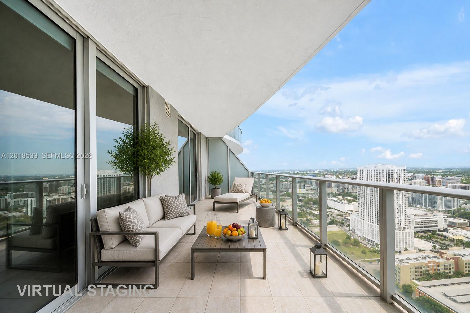 A virtual staging of a high-rise balcony featuring outdoor furniture and a city view — 488 NE 18th St # 4005, Miami FL 33132, MIAMI, FL