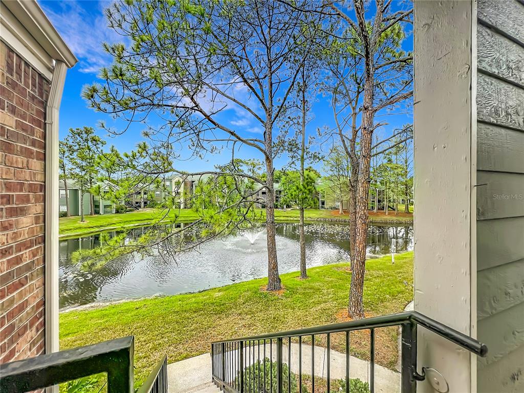 A view from a balcony overlooking a pond with a fountain and surrounding apartment buildings — 2225 METROPOLITAN WAY UNIT 1225, ORLANDO, FL