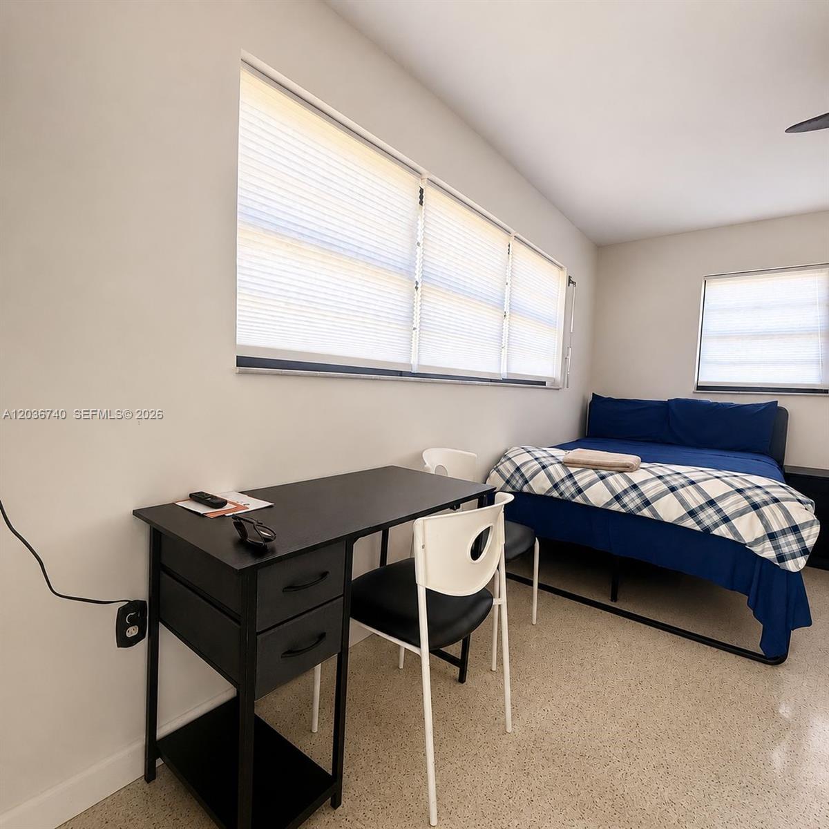 A bedroom features a black desk, a white chair, and a bed with blue bedding — 3202 Pierce St, Hollywood FL 33021, HOLLYWOOD, FL