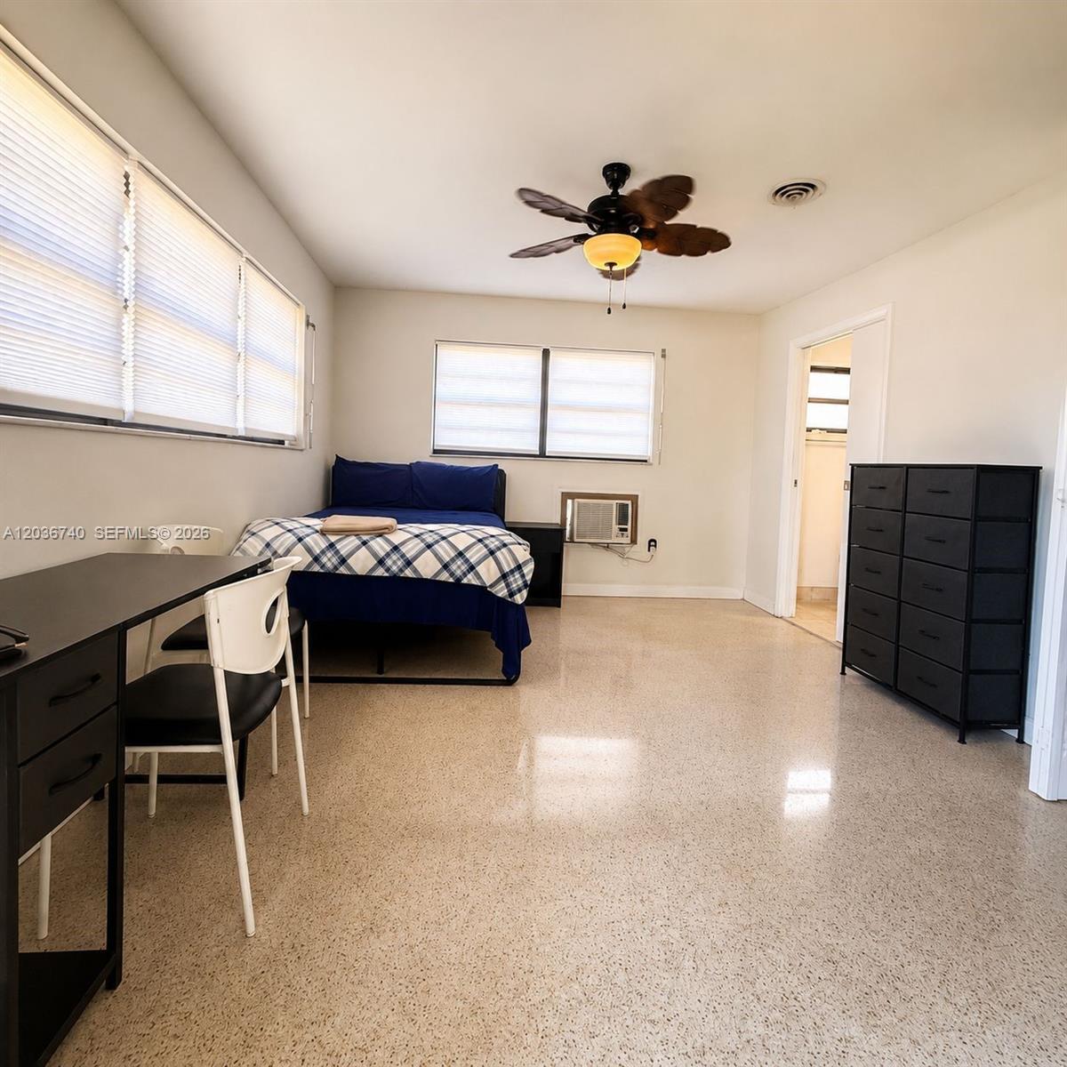 A bedroom features a bed, a desk, a dresser, and a ceiling fan on terrazzo flooring — 3202 Pierce St, Hollywood FL 33021, HOLLYWOOD, FL