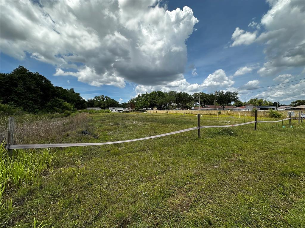 A grassy, vacant lot is enclosed by a simple post and tape fence — 11580 HENDERSON ROAD, TAMPA, FL