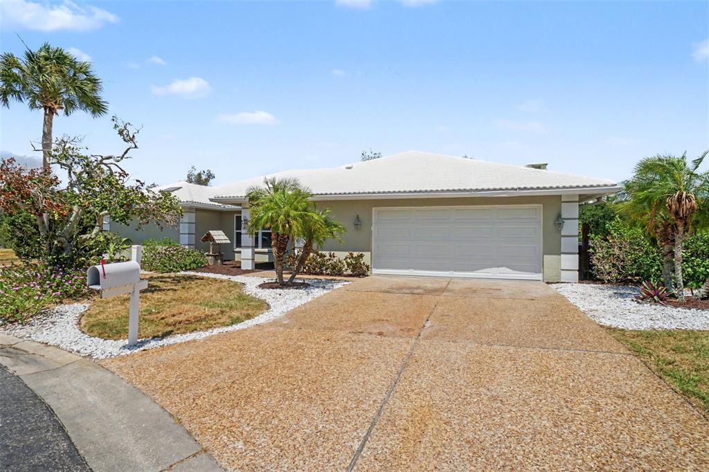 A single-story house with a white garage door, a concrete driveway, and palm trees — 1130 MISTI COURT, VENICE, FL