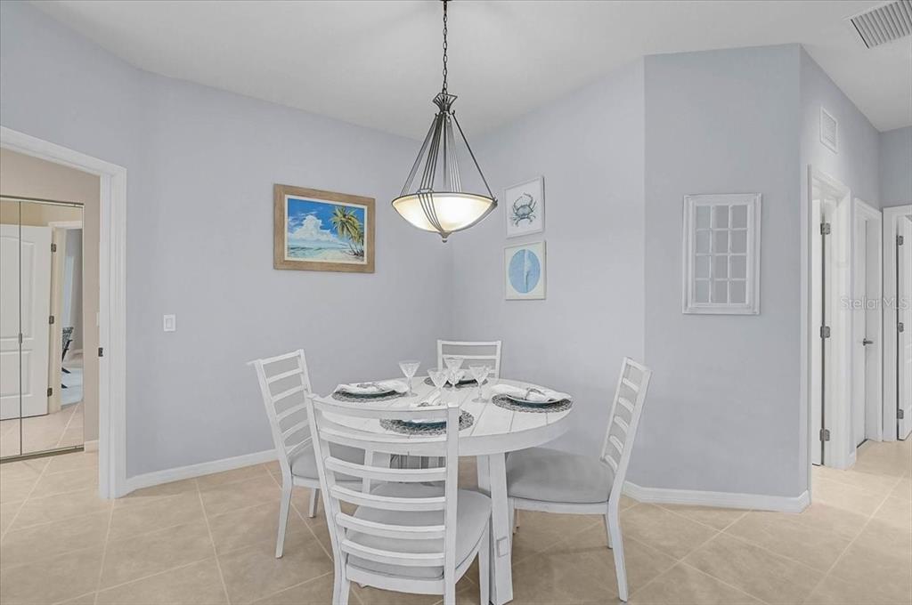 A dining area features a white round table, four chairs, and a pendant light fixture — 1631 MONARCH DRIVE UNIT 1631, VENICE, FL