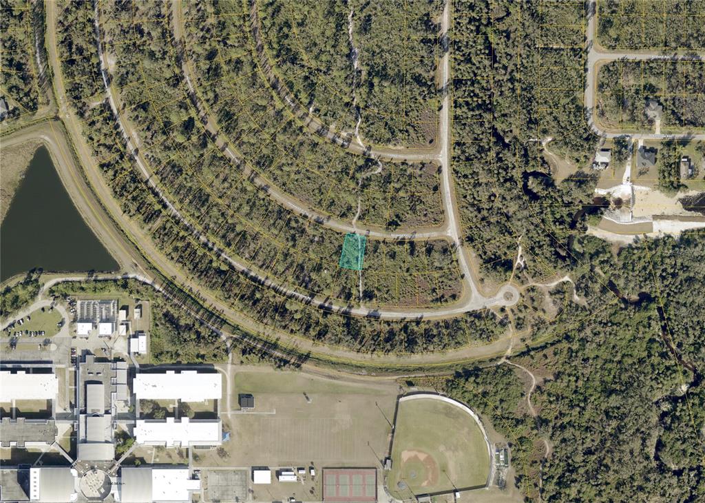An aerial view shows a highlighted vacant lot within a residential subdivision near a school — HERMOSA (LOT 5) CIRCLE, NORTH PORT, FL