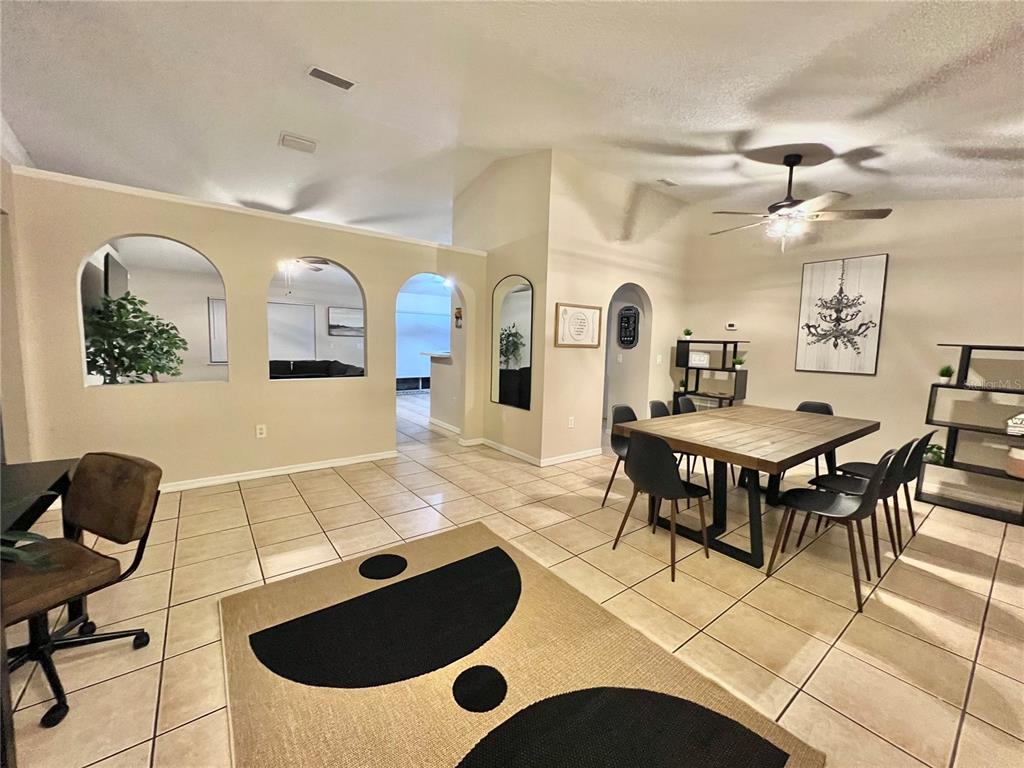 A dining area with tile floors, a wooden table, and arched wall openings — 331 MARQUEE DRIVE, KISSIMMEE, FL