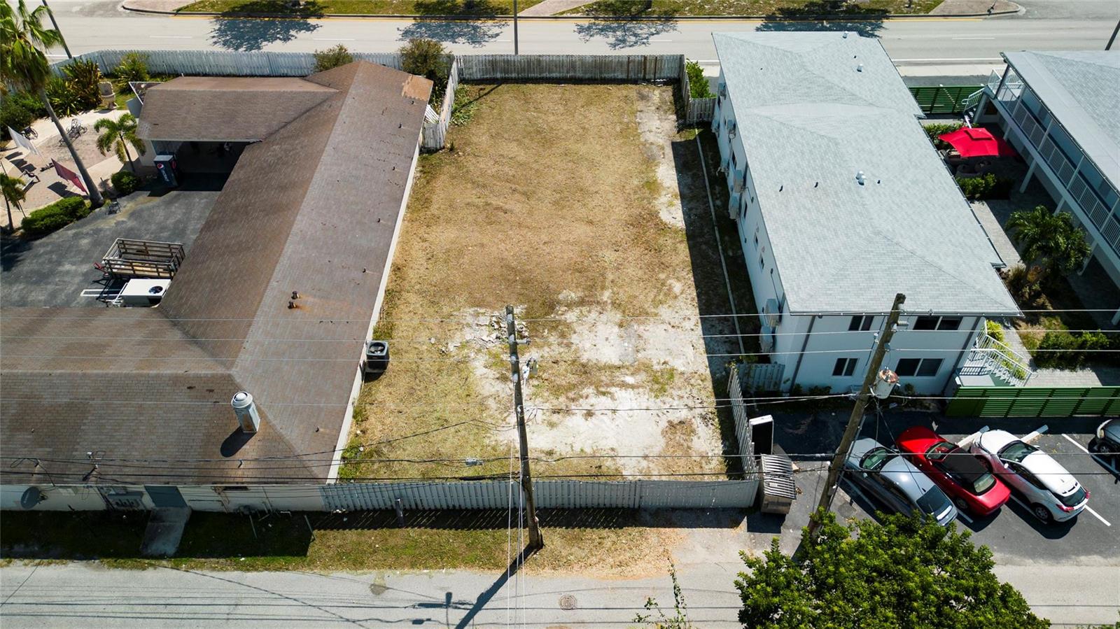 An aerial view shows a vacant rectangular lot situated between two existing residential buildings — Broadway, West Palm Beach FL 33407, WEST PALM BEACH, FL