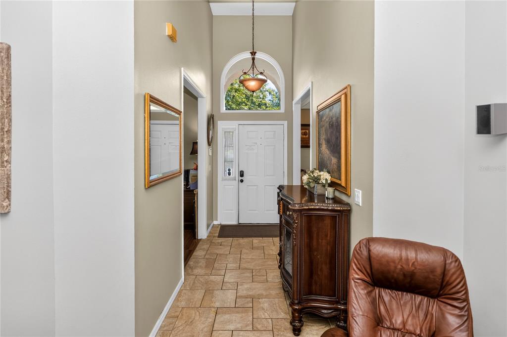 A tiled entryway features a high ceiling, a pendant light, and a white front door — 1907 WESTBOURNE DRIVE, OVIEDO, FL