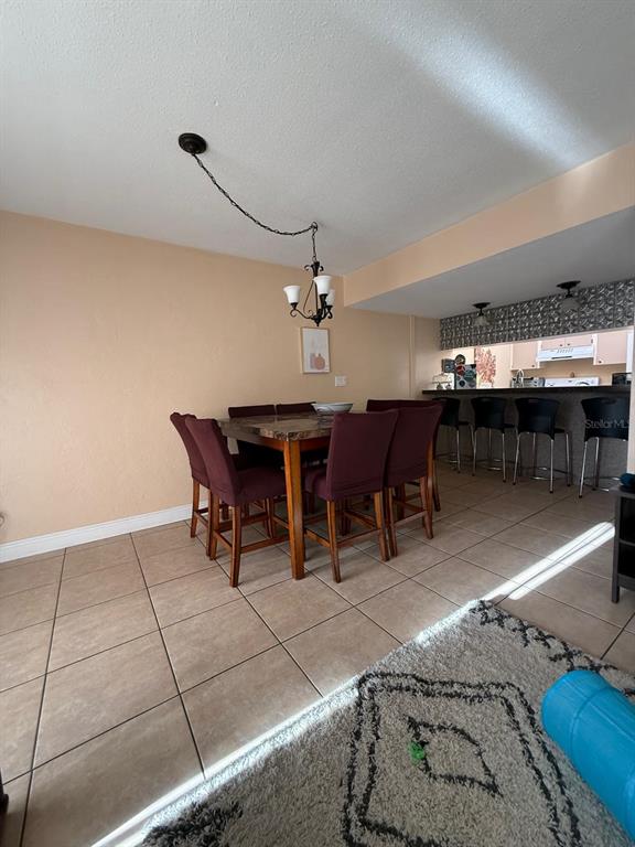 A dining area with a table, six chairs, and a breakfast bar with stools — 821 PINEWOOD COURT UNIT 821, HAINES CITY, FL