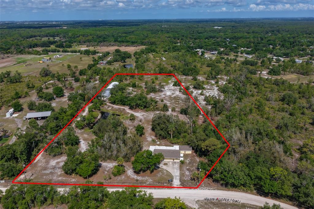 An aerial view shows a house and a detached structure on a large, wooded lot — 14451 HIGHLAND ROAD, WIMAUMA, FL