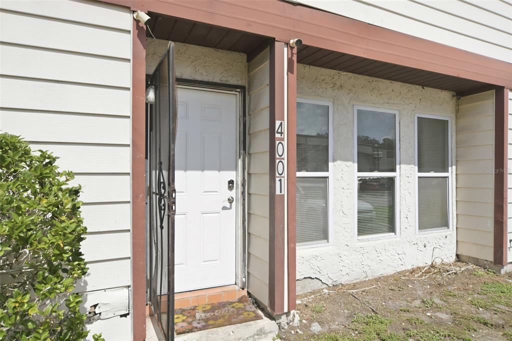 The exterior of a residential building features a white front door and three windows — 4001 DOLOMITE STREET UNIT B1, ORLANDO, FL
