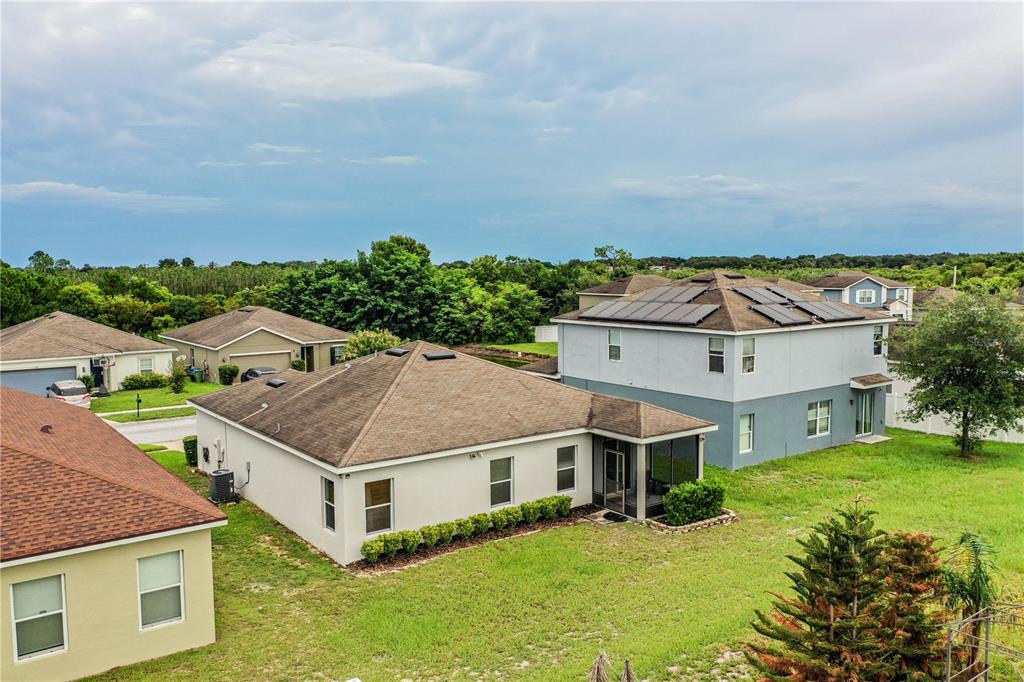 An aerial view shows several suburban houses with shingled roofs and backyards under a cloudy sky — 256 OLEANDER STREET, WINTER HAVEN, FL