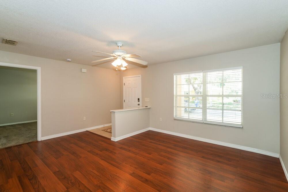 A living room with wood-look flooring, a ceiling fan, and a partial entryway wall — 10334 SUMMERVIEW CIRCLE, RIVERVIEW, FL