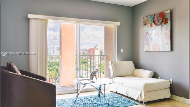 A living room features a dark armchair, a white chaise lounge, and a glass coffee table — 2280 SW 32nd Ave # 613, Miami FL 33145, MIAMI, FL