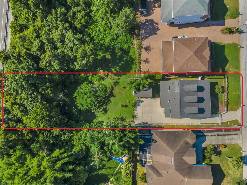 An aerial view shows a residential property with a house, driveway, and large backyard — 3550 ROLANDO DRIVE, PALM HARBOR, FL