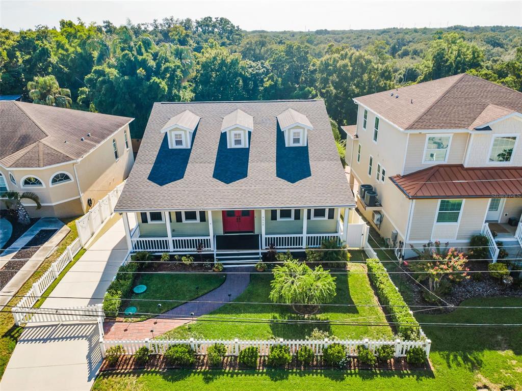 An aerial view shows a house with a front porch, three dormers, and a white fence — 3550 ROLANDO DRIVE, PALM HARBOR, FL