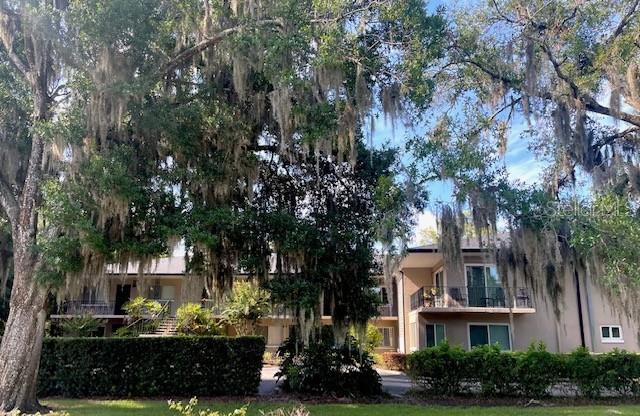 A multi-story apartment building is partially obscured by large trees draped in Spanish moss — 644 N KNOWLES AVENUE UNIT 3, WINTER PARK, FL