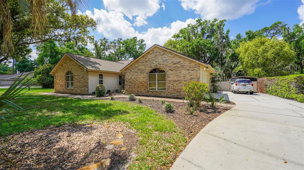 A single-story brick house with a concrete driveway and a white car parked outside — 204 BRYNWOOD LANE, SANFORD, FL