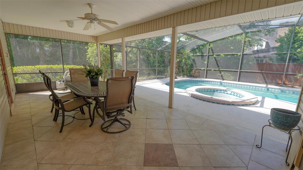 A screened-in patio features tile flooring, a dining set, and an adjacent swimming pool — 204 BRYNWOOD LANE, SANFORD, FL
