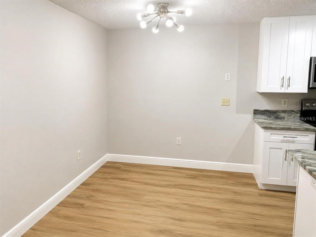 A dining area with light gray walls, wood-look flooring, and a modern sputnik chandelier — 956 SALT POND PLACE UNIT 204, ALTAMONTE SPRINGS, FL
