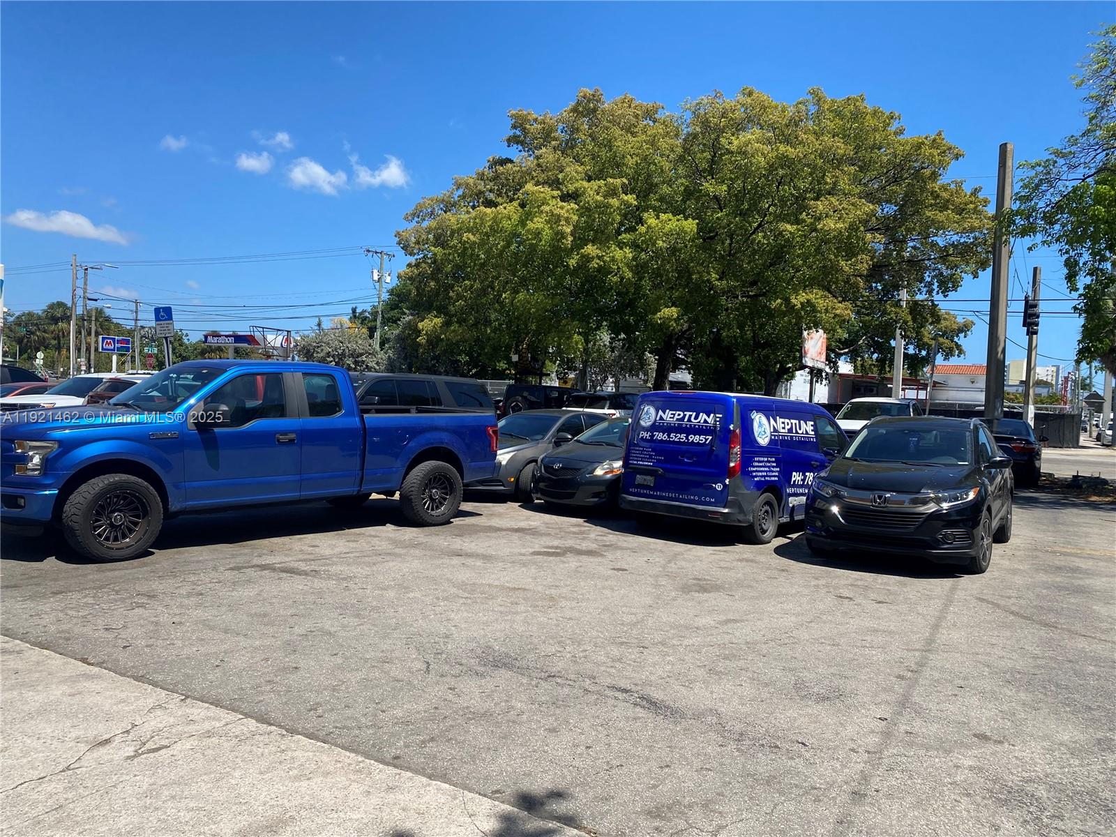 A parking lot features a blue pickup truck, a service van, and several passenger cars — 2300 NW 17th St, Miami FL 33142, MIAMI, FL