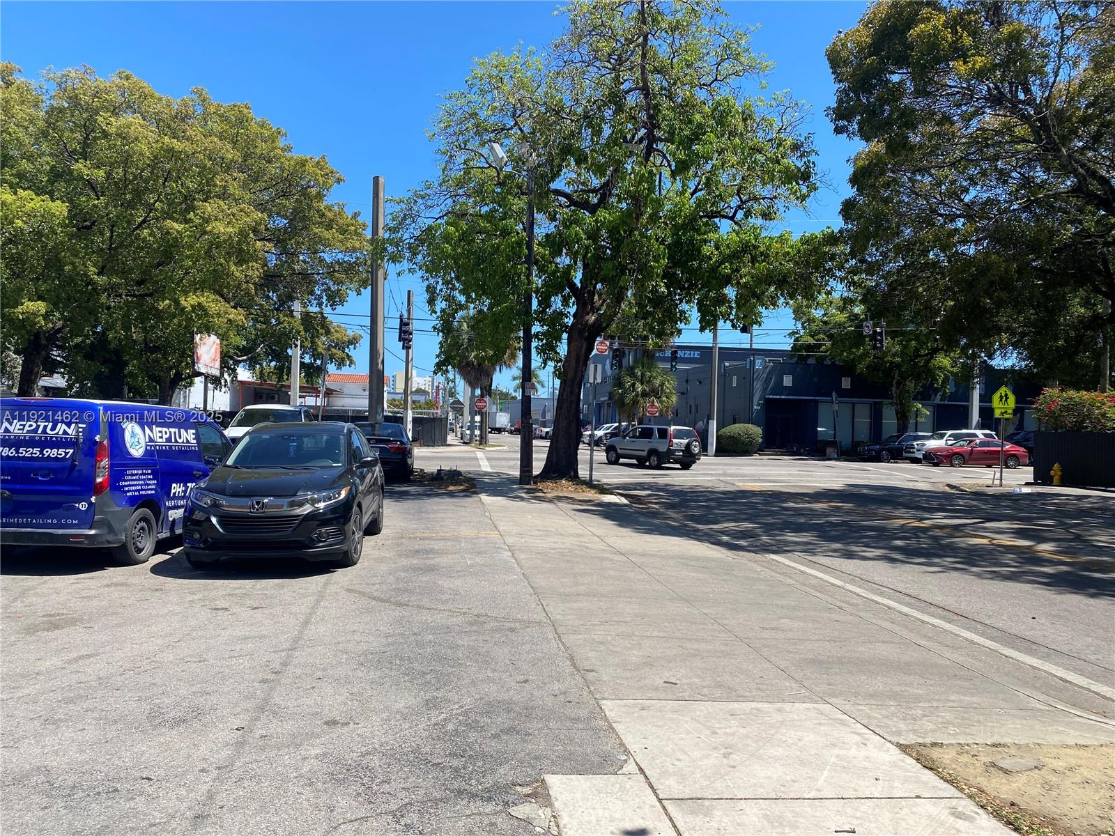 A street view shows parked vehicles, a large tree, and a commercial building under blue skies — 2300 NW 17th St, Miami FL 33142, MIAMI, FL