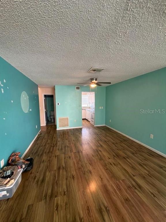 An open living area features teal walls, wood-look flooring, and a ceiling fan — 1500 SUNSET ROAD UNIT A6, TARPON SPRINGS, FL