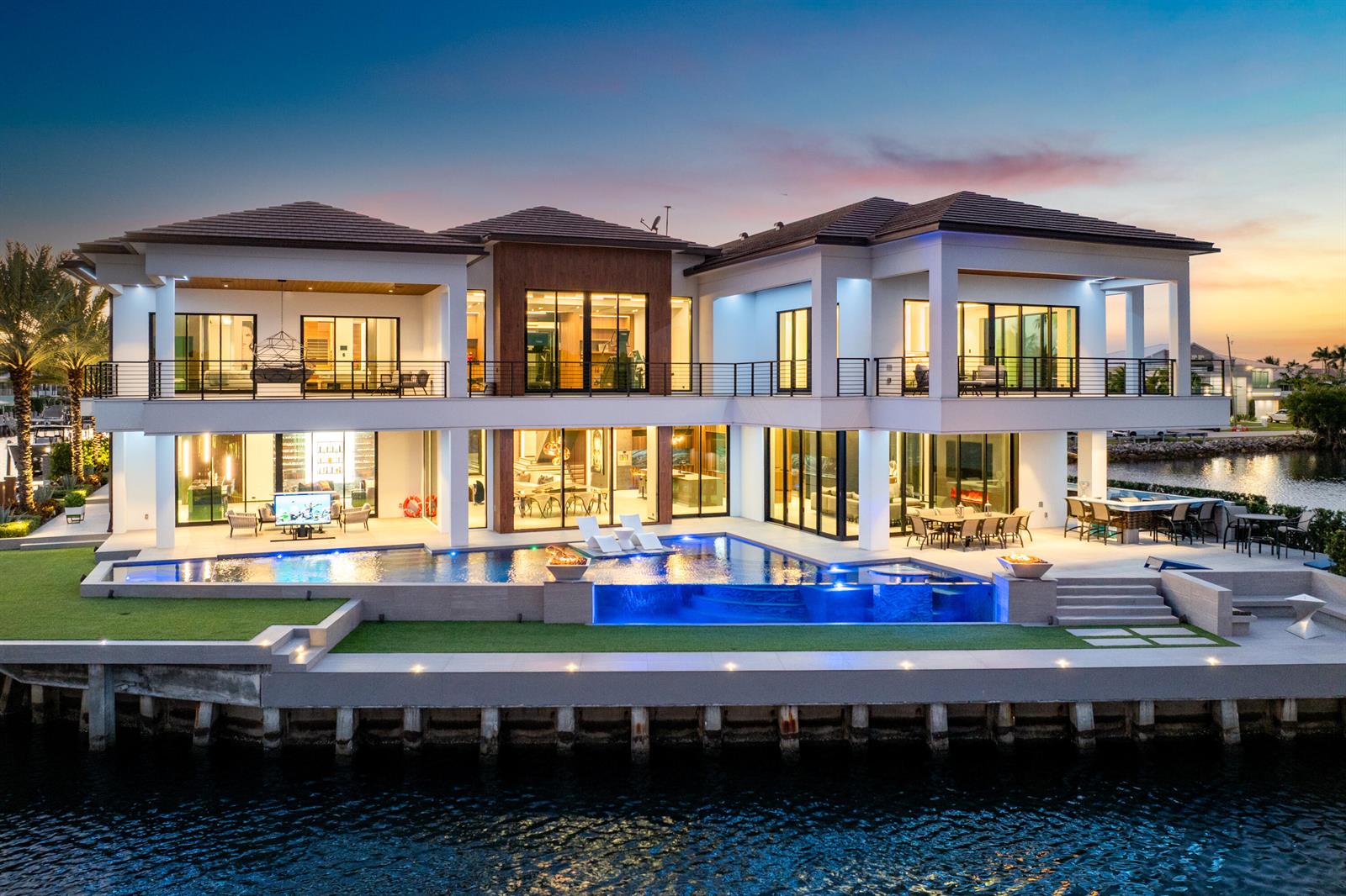 A modern two-story waterfront mansion features a large infinity pool, balcony, and outdoor dining area — 2934 NE 8th Avenue, Boca Raton FL 33431, BOCA RATON, FL