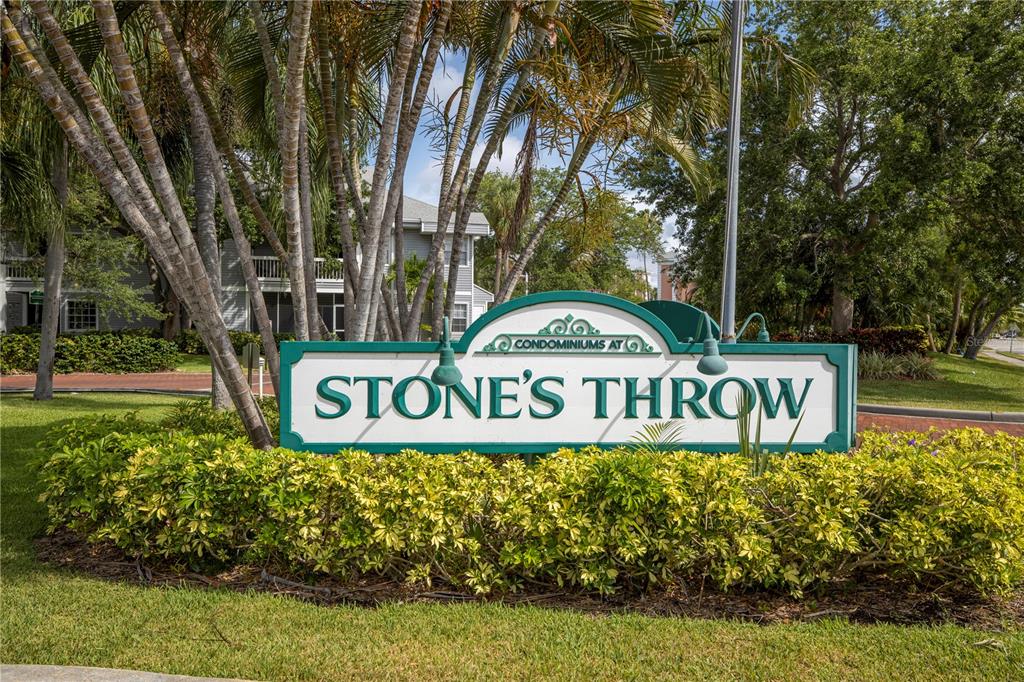 A sign for the Condominiums at Stone's Throw stands in front of palm trees and landscaping — 6826 STONES THROW CIRCLE N UNIT 11108, ST PETERSBURG, FL
