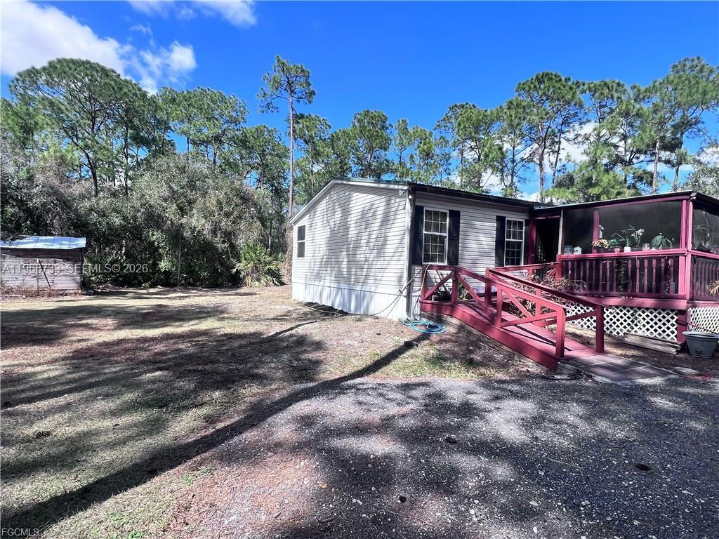 A single-story house with white siding and a red wooden ramp leading to a porch — 680 S Arboleda, Clewiston FL 33440, CLEWISTON, FL