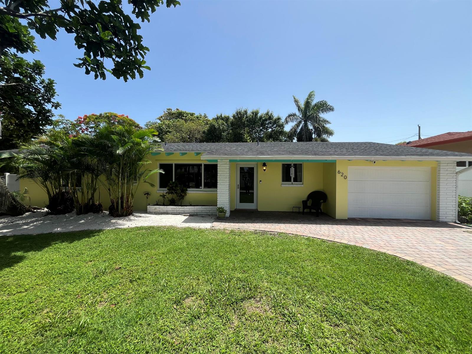 A yellow single-story house with a white garage door and a brick-paved driveway — 620 NE 9th Avenue, Boynton Beach FL 33435, BOYNTON BEACH, FL
