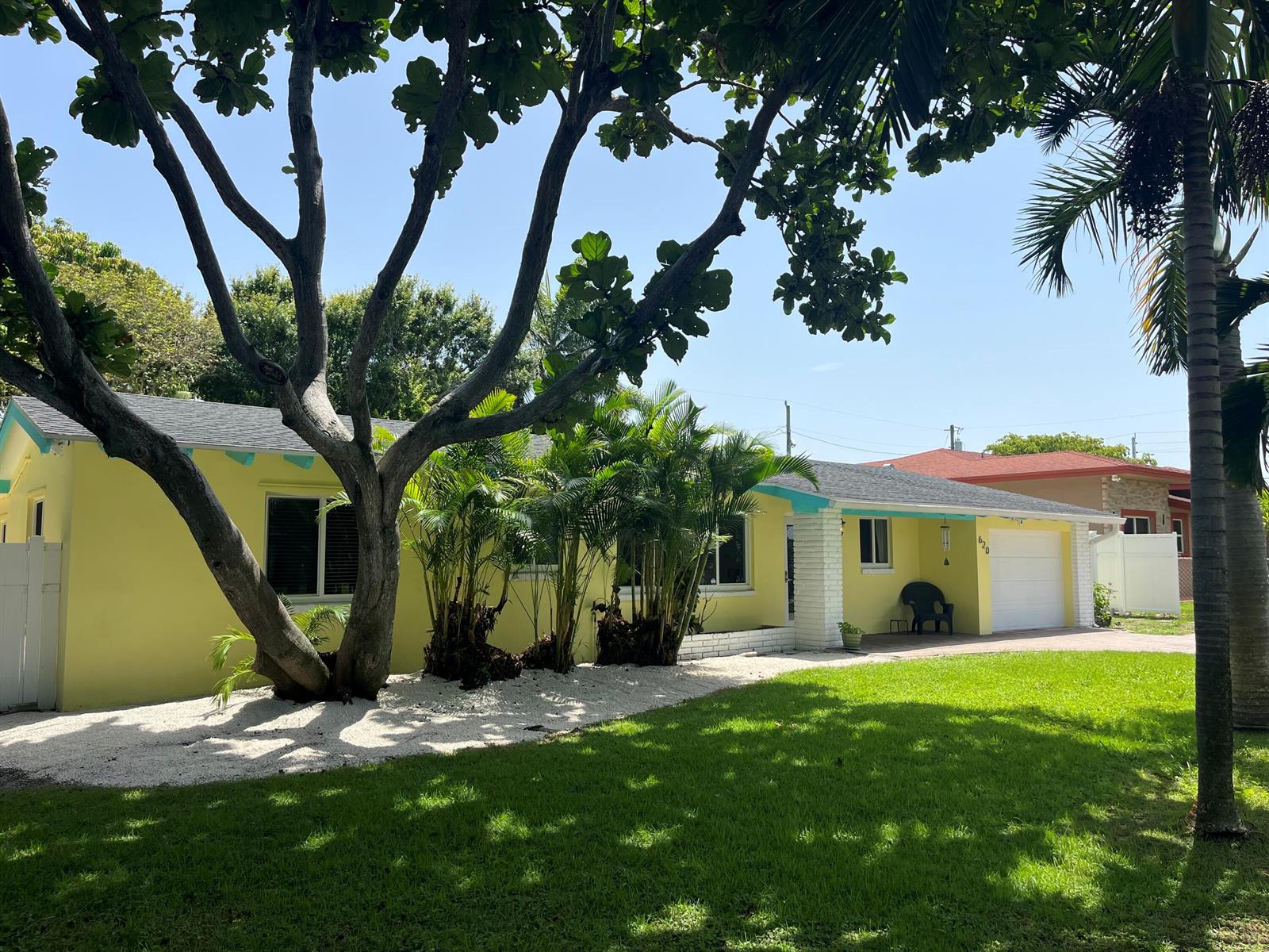 A yellow single-story house with a white garage, palm trees, and a gravel front yard — 620 NE 9th Avenue, Boynton Beach FL 33435, BOYNTON BEACH, FL