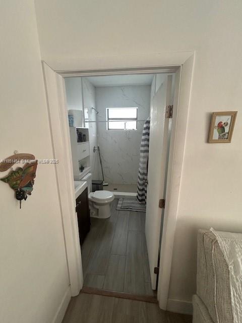 A view through a doorway into a bathroom with a toilet, shower, and tiled floors — 3066 NW 92nd St, Miami FL 33147, MIAMI, FL