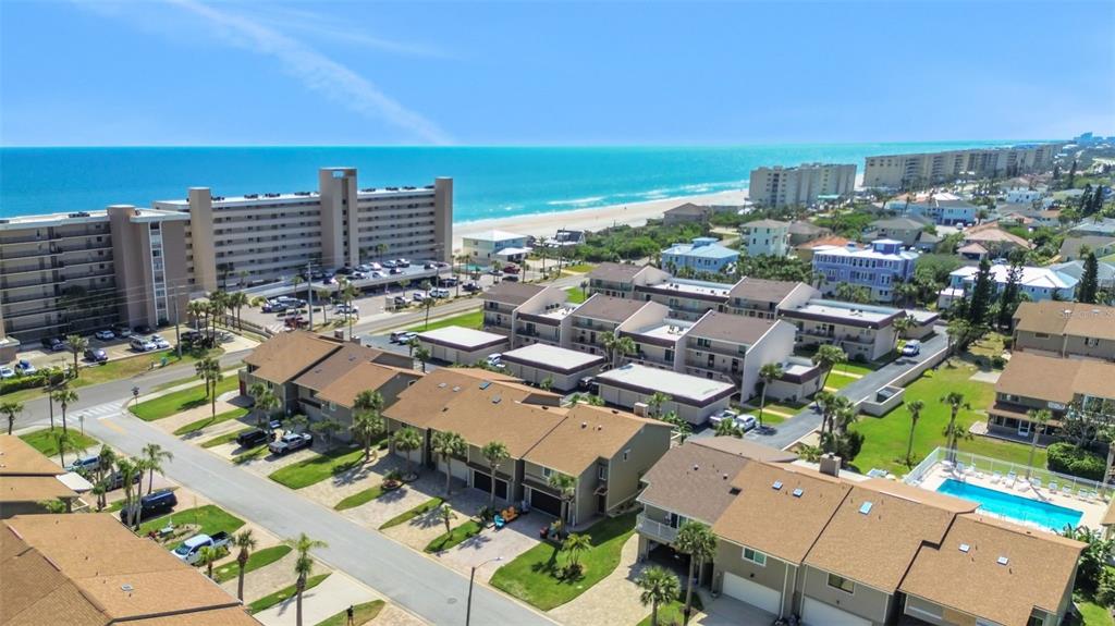 An aerial view of a coastal residential neighborhood with townhomes, a pool, and a beach — 33 SEA HAVEN DRIVE, PONCE INLET, FL