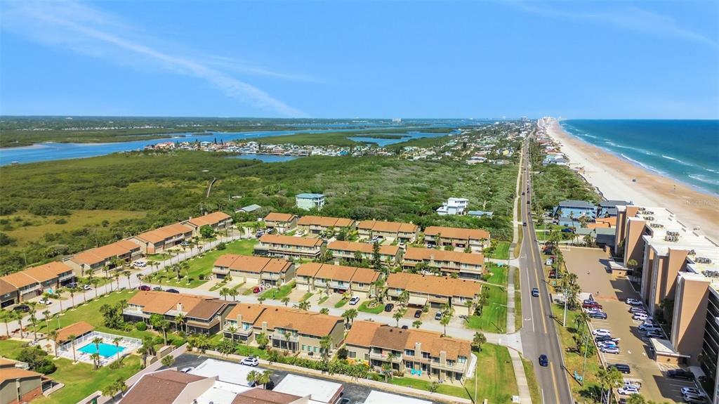 An aerial view shows a coastal residential complex with a swimming pool near the beach — 33 SEA HAVEN DRIVE, PONCE INLET, FL