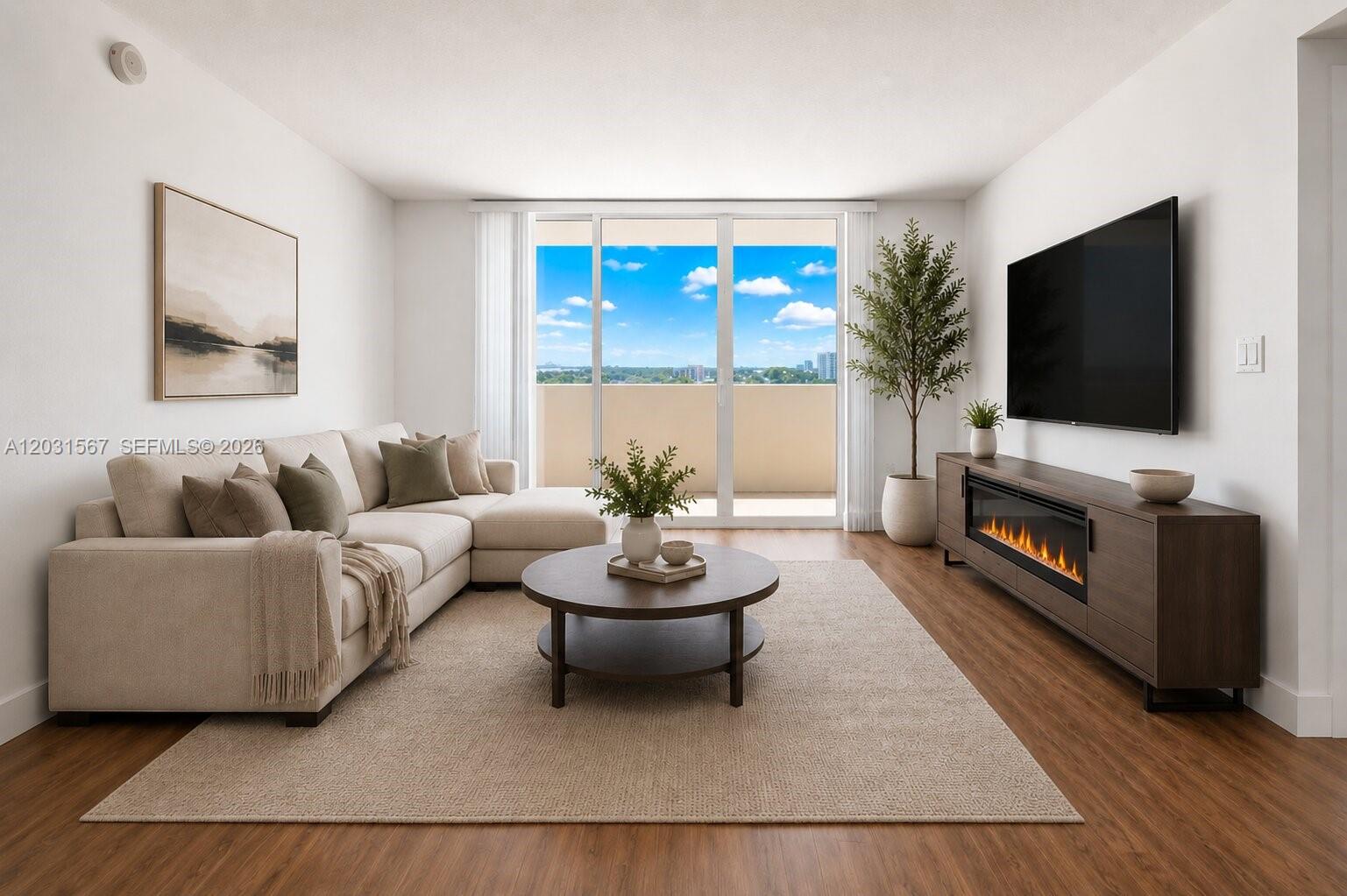 A living room features a beige sectional sofa, a round coffee table, and a fireplace console — 3232 SW 22nd Ter # 802, Miami FL 33145, MIAMI, FL