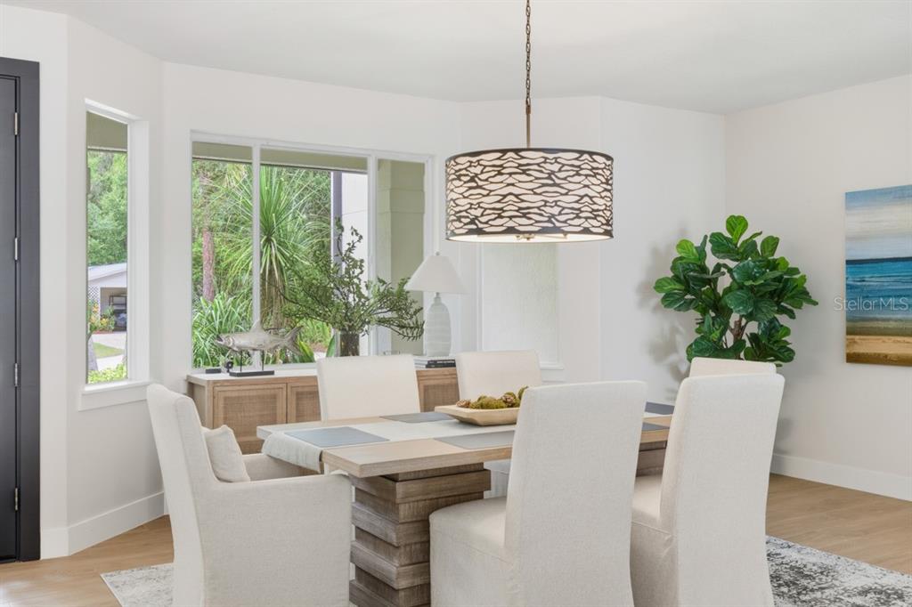 A dining room features a wooden table, upholstered chairs, a patterned pendant light, and windows — 4733 CHULUOTA ROAD, ORLANDO, FL