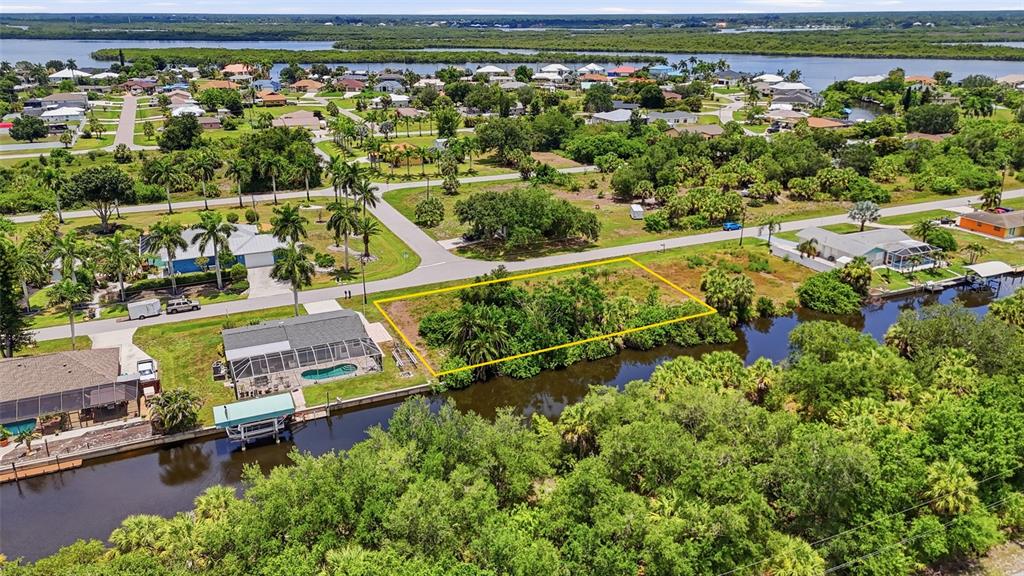 An aerial view shows a vacant, rectangular lot bordered by a canal and residential homes — 3367 DESOTO DRIVE, PUNTA GORDA, FL