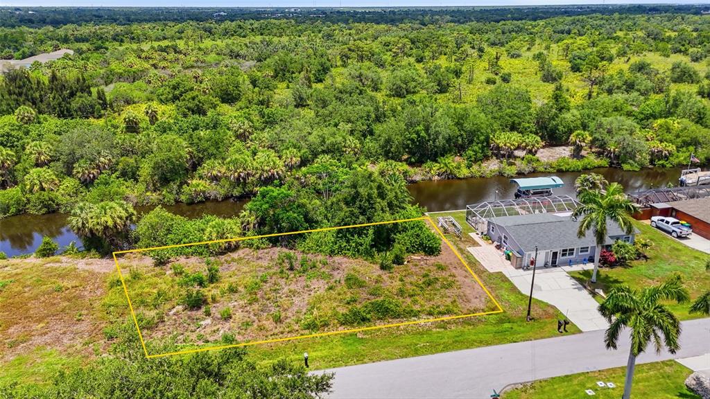 An aerial view shows a vacant rectangular lot next to a house with a pool — 3367 DESOTO DRIVE, PUNTA GORDA, FL