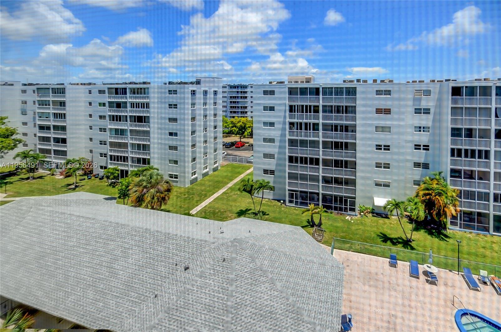 An elevated view shows two large apartment buildings separated by a grassy courtyard and pool — 301 NE 14th Ave # 702, Hallandale Beach FL 33009, HALLANDALE BEACH, FL