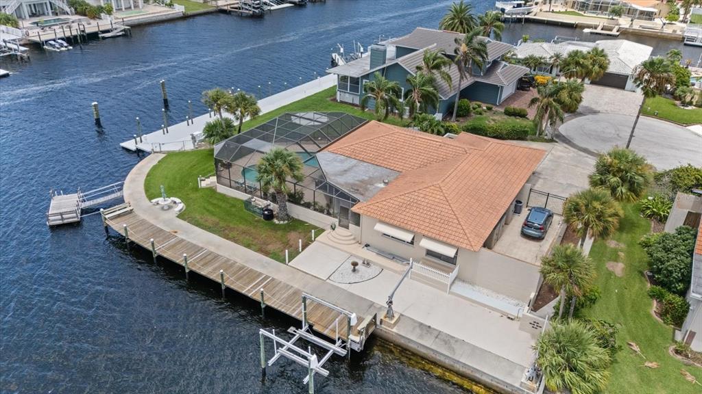 A single-story house with a tile roof, concrete driveway, and gated side yard at sunset — 3154 TRIDENT TERRACE, NEW PORT RICHEY, FL
