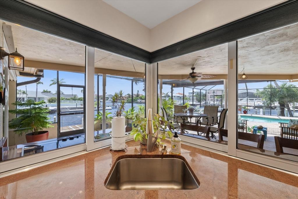 An aerial view shows waterfront houses with private docks along a canal leading to open water — 3154 TRIDENT TERRACE, NEW PORT RICHEY, FL