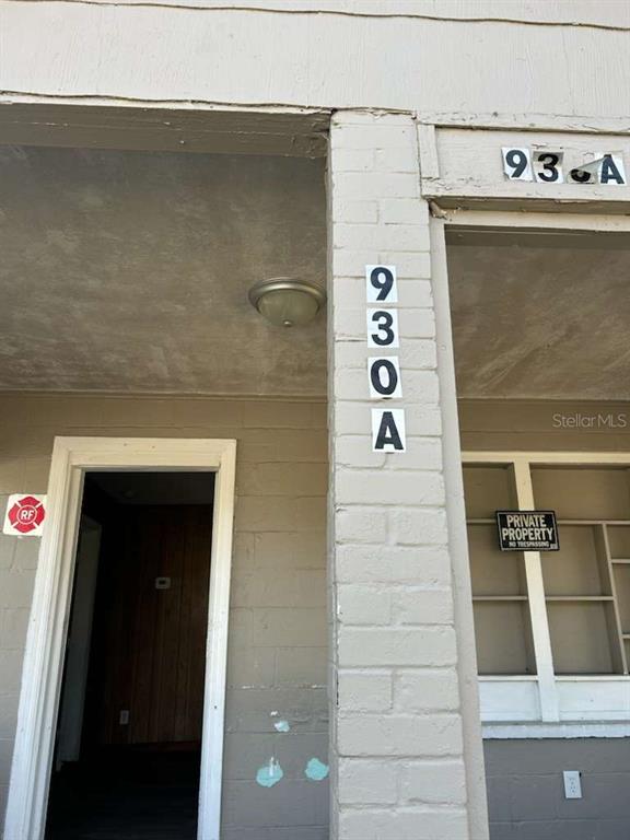 The exterior of a building shows a doorway, a window, and the address 93A — 930 18TH STREET UNIT A, ORLANDO, FL