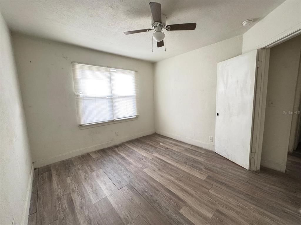 An empty bedroom features light-colored walls, a ceiling fan, and wood-look laminate flooring — 930 18TH STREET UNIT A, ORLANDO, FL