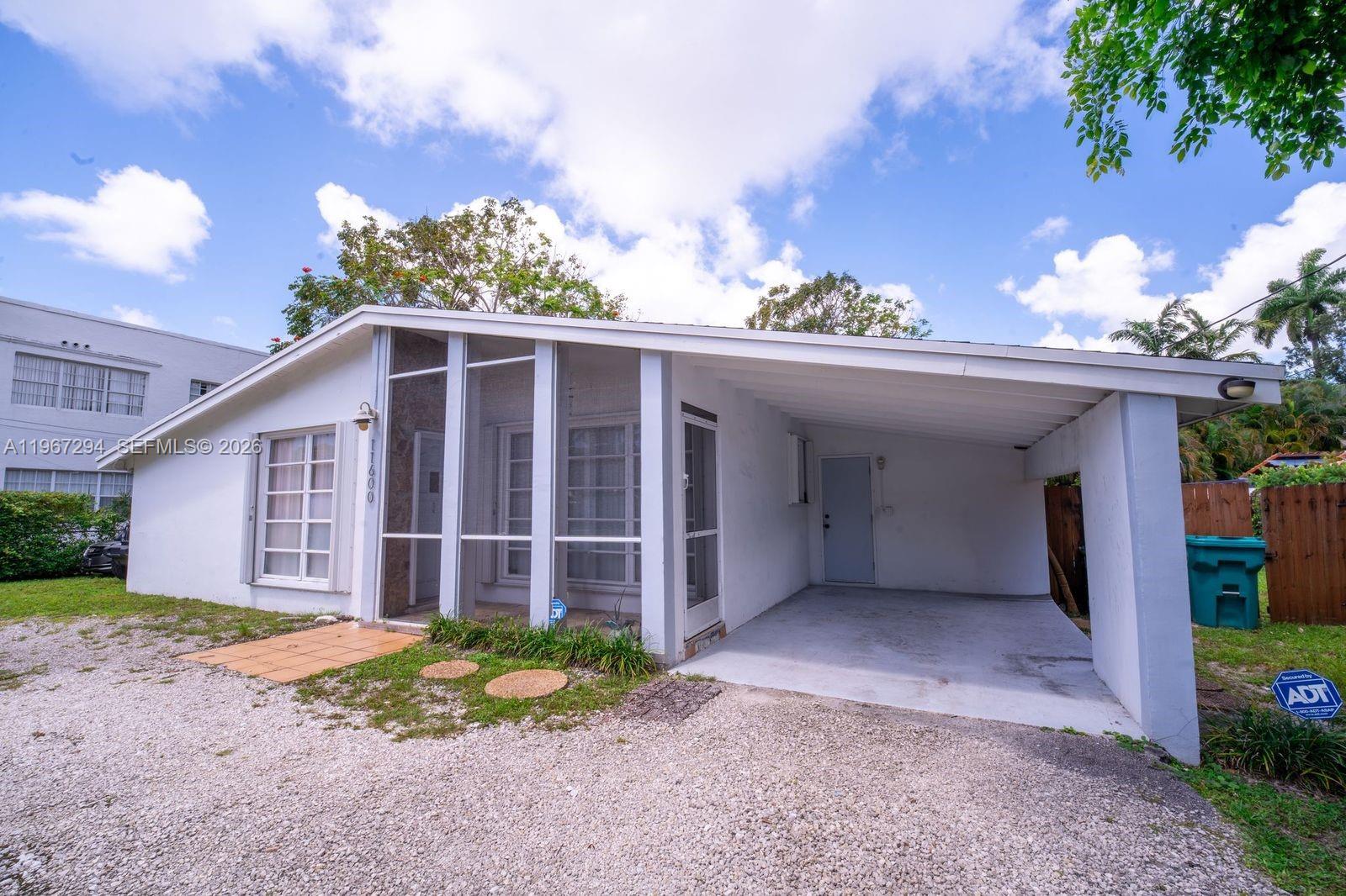 A white single-story house features a screened-in front porch and an attached carport — 11600 NE 6th Ave, Biscayne Park FL 33161, BISCAYNE PARK, FL