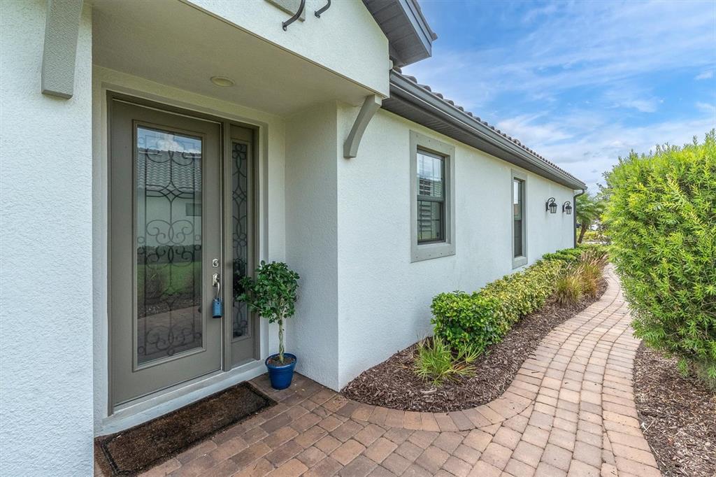 The exterior of a house features a paved walkway, a front door, and landscaping — 3142 FRANCOA DRIVE, ODESSA, FL