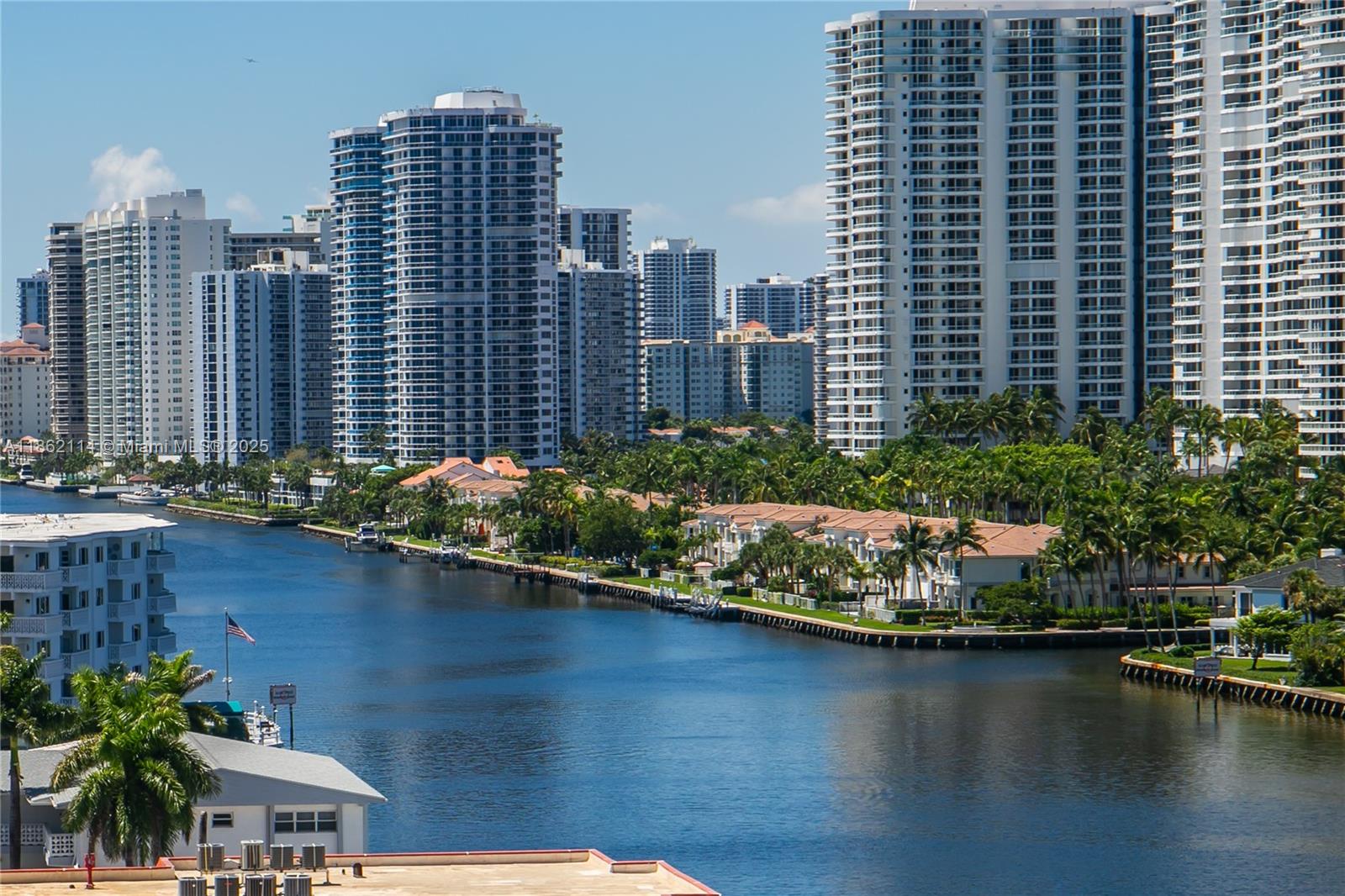 An elevated view of a canal lined with palm trees, townhomes, and high-rise apartment buildings — 2017 S Ocean Dr # 1008, Hallandale Beach FL 33009, HALLANDALE BEACH, FL