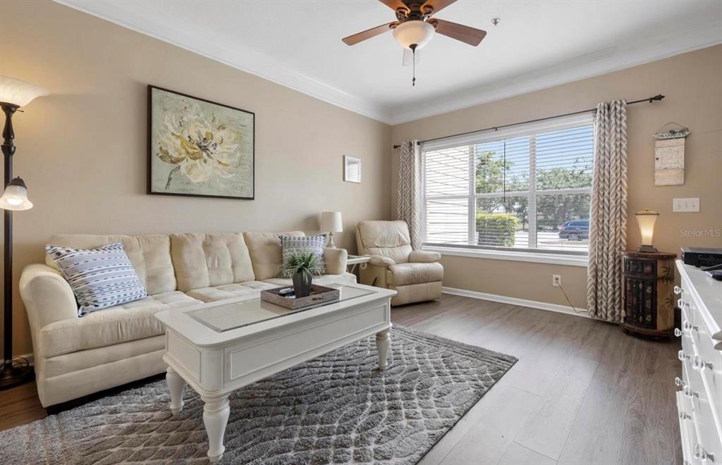 A living room features a beige sofa, a white coffee table, and a large window — 4802 51ST STREET W UNIT 1908, BRADENTON, FL