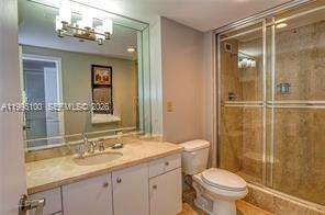 A bathroom features a vanity with a sink, a mirror, and a glass-enclosed shower — 1800 NE 114th St # 401, Miami FL 33181, MIAMI, FL