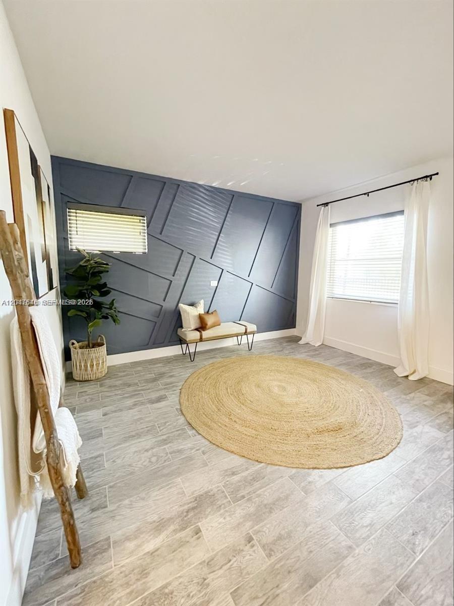 A room features a blue accent wall with geometric molding, a jute rug, and tile flooring — 1040 Lenox Ave # 1040, Miami Beach FL 33139, MIAMI BEACH, FL